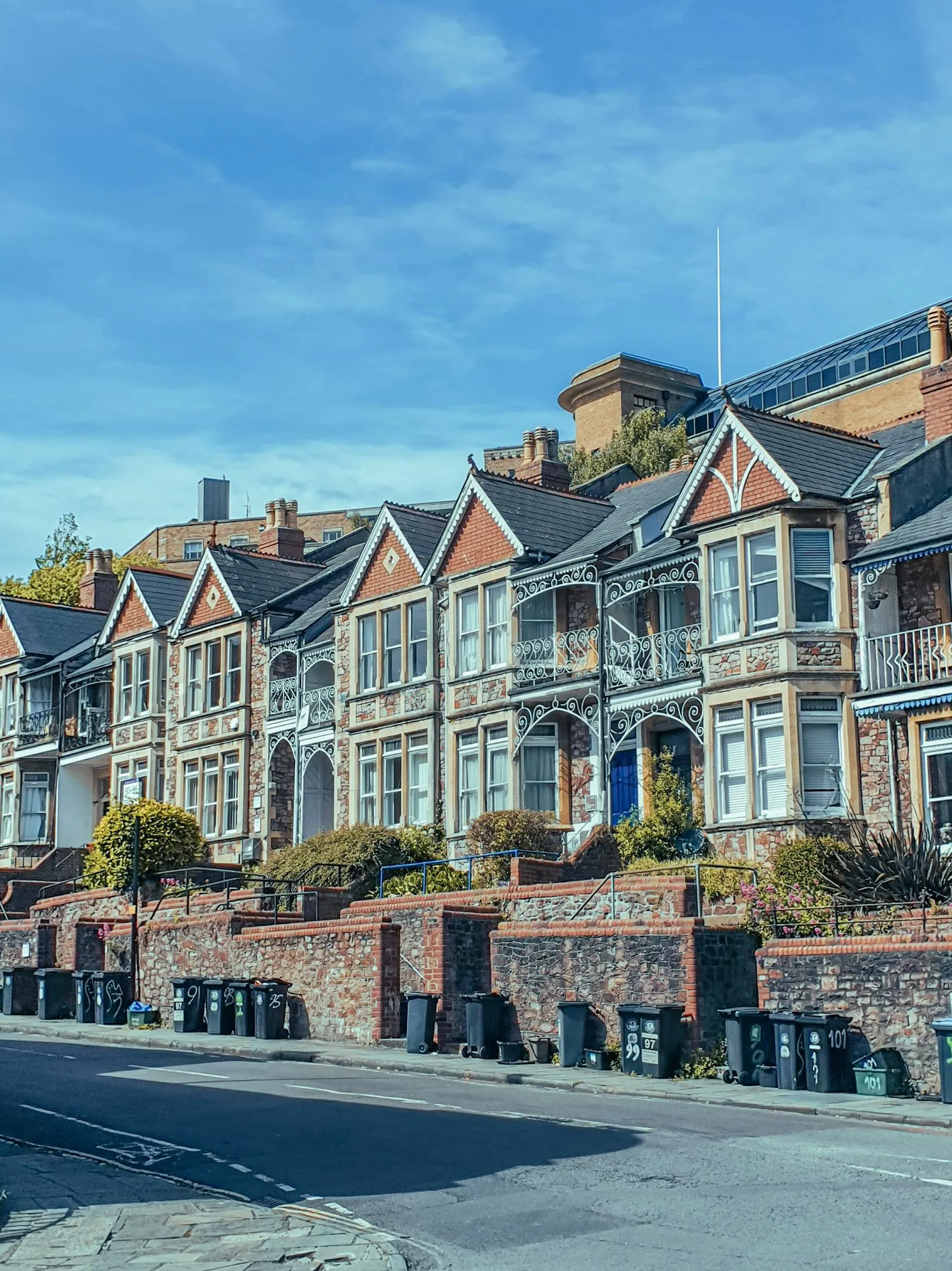 A row of Victorian terraced houses with decorative wrought-iron balconies on a Bristol hill street — period housing stock common across the city's inner south-Bristol neighbourhoods, including Bedminster.